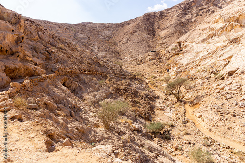 Valley of the Caves in Mleiha Archaeological Centre in Sharjah, footpath leading to neolithic period caves, limestone mountains landscape.