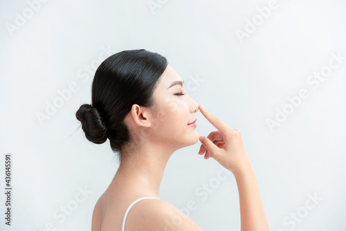 Side profile of asian lady pointing her nose