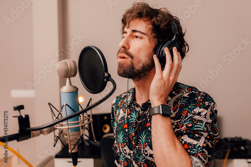 Young singer laying down tracks in a recording home studio