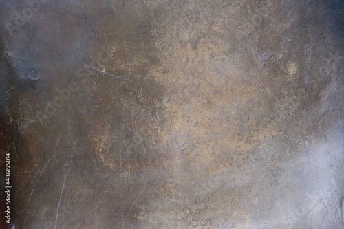 The texture of the worn bronze or brass background is covered with a patina 