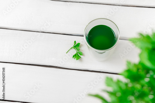 Top view of chlorophyll water in a glass on white wooden table with copy space