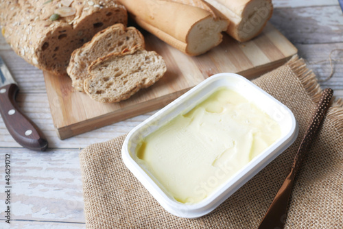 cutting butter on chopping board and brown bread on background 