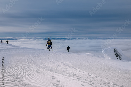 Freeriders skiers and snowboarders on a mountain slope against a background of fog in ski resort in the Arctic. Russia, Murmansk region