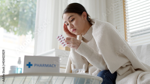 Young asian woman receive check read medication capsule drug label package box free first aid kit from pharmacy hospital delivery service or drugstore at home in online telehealth telemedicine.
