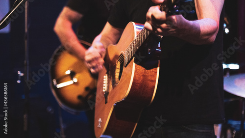 Close up of guitarist musician playing guitar on stage.