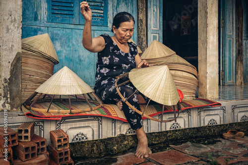 Vietnamese Old woman craftsman making the traditional vietnam hat in the old traditional house in Ap Thoi Phuoc village, Hochiminh city, Vietnam, traditional artist concept