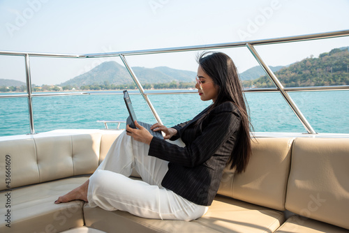 Asian young businesswoman with laptop at the yacht in summer