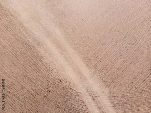A plowed field with a path. Texture, background. Aerial photo