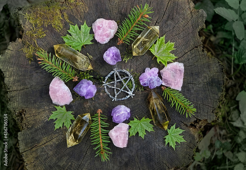 mineral gemstones, pentagram and forest leaves on natural background. Healing quartz stones for Crystal Ritual, Esoteric spiritual practice. modern wicca magic. flat lay