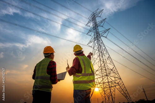 electrical engineer working at the power station See the planning of electricity production at high voltage poles.