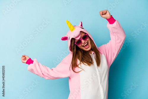 Young woman wearing an unicorn costume with sunglasses isolated