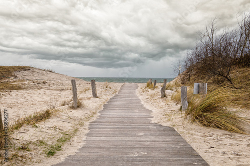 Path to the Baltic beach made of wood with dunes and cloudy sky