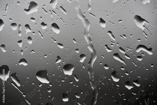 Image of water droplets on a clear glass surface during heavy rain.