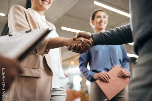 Close-up of business partners shaking hands after successful meeting in the office.