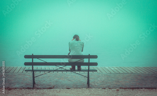 Depressive Frau sitzt auf Bank.