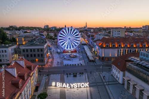 Białystok, widok z lotu ptaka o zmierzchu na Ratusz, Rynek Kościuszki, koło widokowe i napis #Białystok