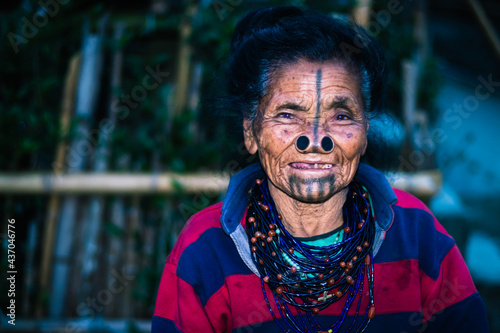 apatani tribal women facial expression with her traditional nose lobes and blurred background image is taken at ziro arunachal pradesh india. it is one of the oldest tribe of india.
