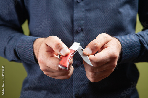 A man opens a hand knife