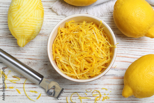 Flat lay composition with fresh lemon zest on white wooden table