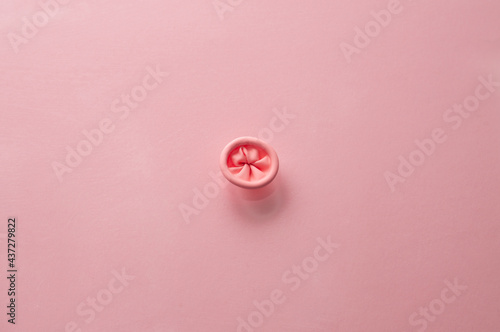 Metaphor image of the anus on a pink background. Rectal health, anus hygiene.