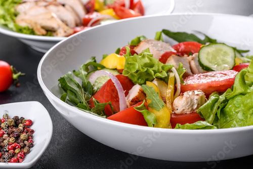 Fresh delicious salad with chicken, tomato, cucumber, onions and greens with olive oil