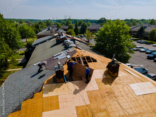 Roof shingles need with new shingles of an apartment building replacing gray asphalt tile