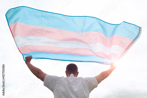 Transgender man holding waving transgender flag, concept picture about human rights, equality in the World