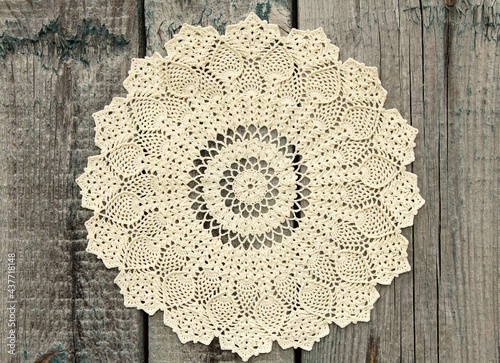 Beautiful crochet doily on old wooden background