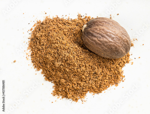 nutmeg seed and powder close up on gray