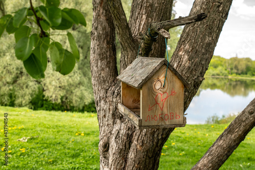 Feeders for birds or squirrels in the tree. House with an inscription in Russian word love
