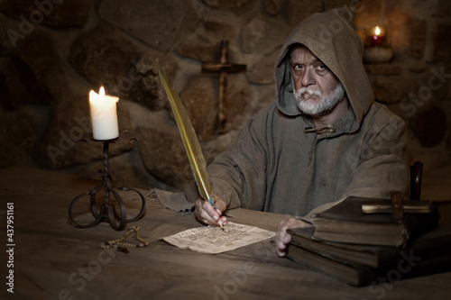 Old monk writes an old letter in the Middle Ages