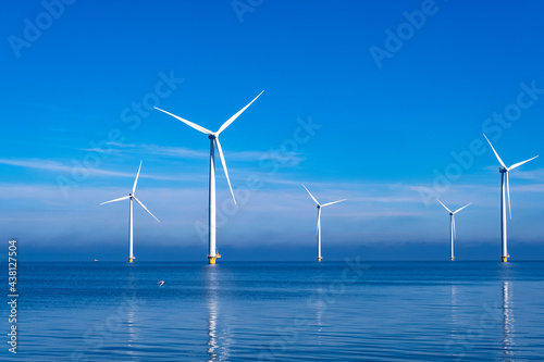 offshore windmill park with clouds and a blue sky, windmill park in the ocean aerial view with wind turbine Flevoland Netherlands Ijsselmeer. Green energy 