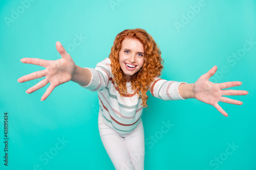 Photo portrait curly woman smiling keeping hands forward missing friend isolated vivid turquoise color background