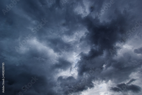 The dark sky had clouds gathered to the right and a strong storm before it rained.Bad or moody weather sky.