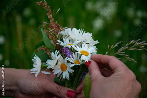 Making a Festive flower wreath, circlet of flowers, festival coronet of flowers on a bright sunny afternoon. Preparing for Midsummer night fest, or bachelorette party idea. How to Make a Flower Crown