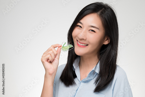 Asian woman holding orthodontic retainers.Teeth retaining tools after braces ...