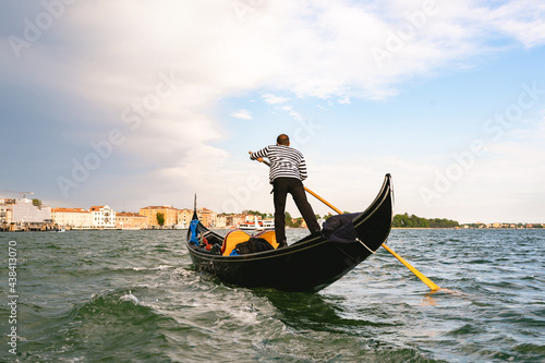 Unrecognizable gondolier man rowing in Venice channels.