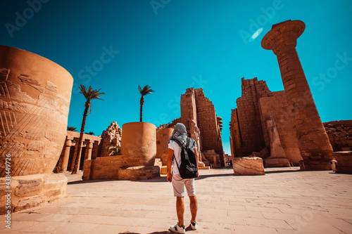 A male tourist stands at the entrance to Karnak Temple, Luxor, Egypt.