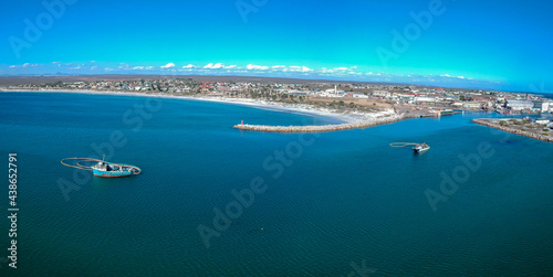 Arial shot of the harbor of Lamberts Bay on the west coast of South Africa. There are two diamond diving boats at anchor in the harbor