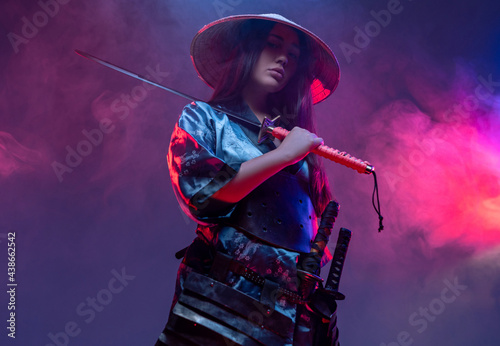 Futuristic female samurai with sword inside studio