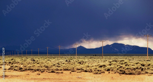 Approaching storm over the mountains and telephone poles during adventures of The West.