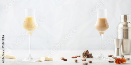 Chocolate cream alcohol liqueur in a glass, pieces of chocolate and cocoa beans.
