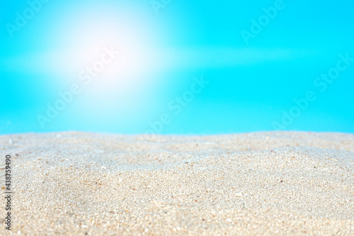 Sea beach sand texture on blue background with selective focus. Summer background concept for products display. 