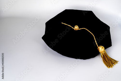 Isolated traditional black phd doctoral tam cap with gold tassel 