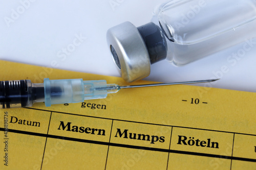 Impfung gegen Masern, Mumps und Röteln mit Impfpass, Spritze und Impfstoff