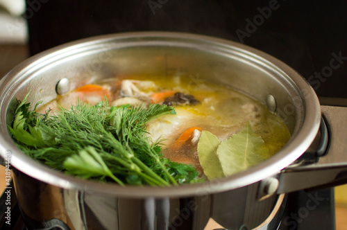 Adding herbs, bay leaves and seasonings to the broth