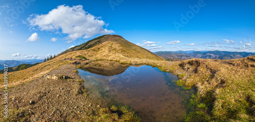 Small picturesque lake with clouds reflections at the Strymba Mount. Beautiful autumn day in Carpathian Mountains near Kolochava village, Transcarpathia, Ukraine.