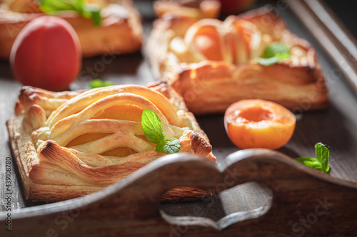 Tasty puff pastry with peaches and mint. Unique yummy cake.