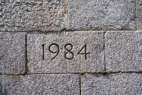 Stone wall of bridge foundation with year 1984 engraved. Photo taken June 13th, 2021, Zurich, Switzerland.