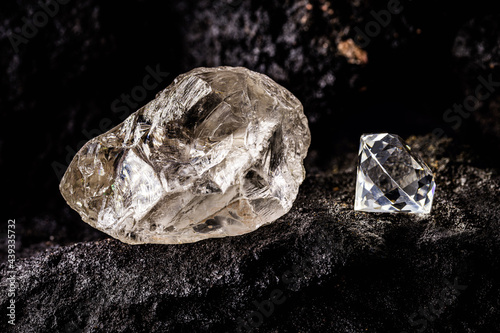 cut diamond with rough diamond gem on kimberlite rock, on isolated background, diamond business concept.